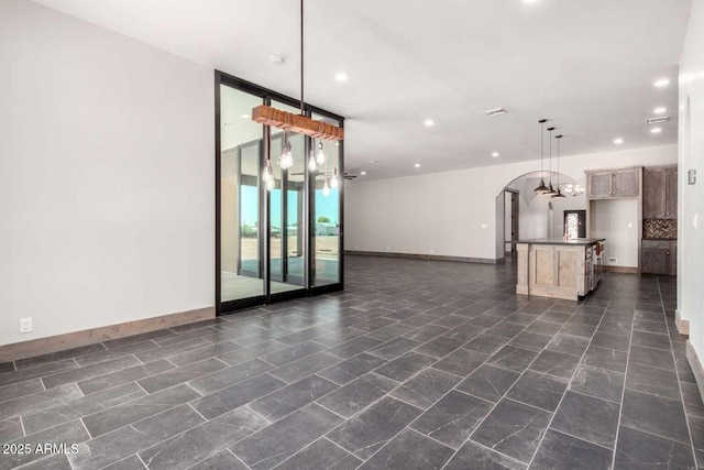 2009 S Raindance Rd, Apache Junction, AZ 85119 - unfurnished living room featuring arched walkways and recessed lighting