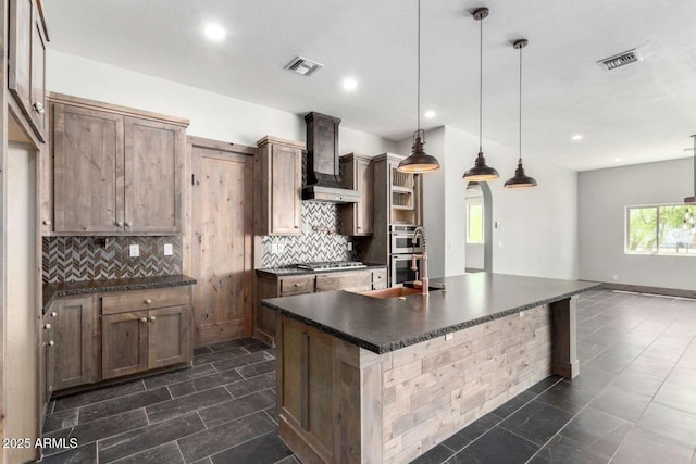 2009 S Raindance Rd, Apache Junction, AZ 85119 - kitchen featuring dark countertops, stainless steel appliances, wall chimney exhaust hood, decorative backsplash, and recessed lighting