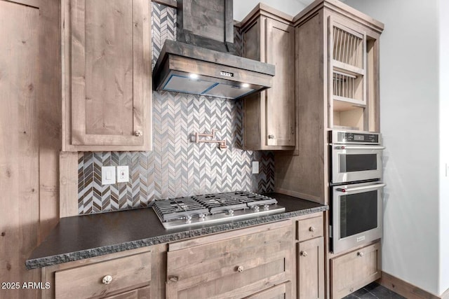 2009 S Raindance Rd, Apache Junction, AZ 85119 - kitchen featuring stainless steel appliances, wall chimney range hood, dark countertops, and decorative backsplash