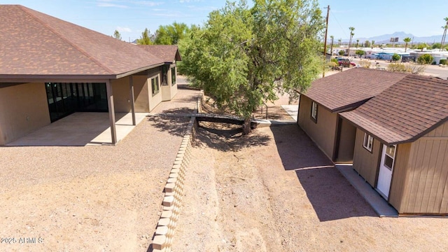 2009 S Raindance Rd, Apache Junction, AZ 85119 - view of side of property featuring a mountain view, stucco siding, and roof with shingles