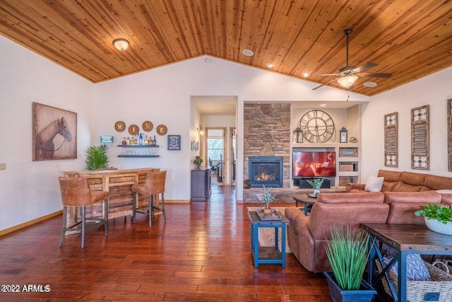 living room with hardwood / wood-style floors, wooden ceiling, and a stone fireplace