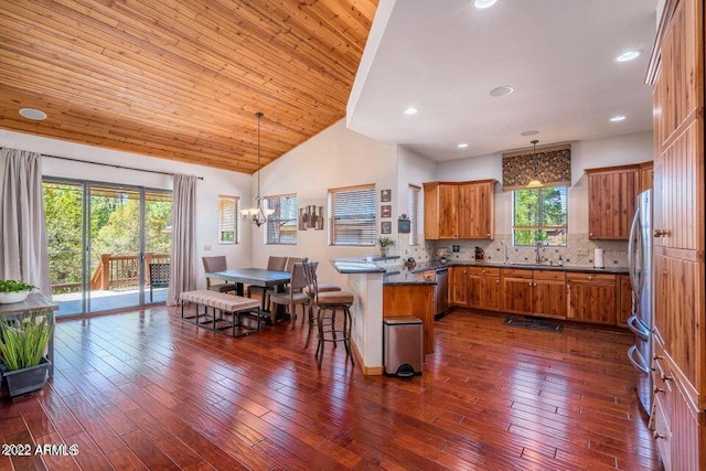 kitchen with backsplash, a wealth of natural light, pendant lighting, and a breakfast bar