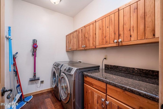 clothes washing area featuring dark hardwood / wood-style flooring, cabinets, and washer and dryer