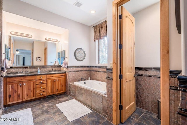 bathroom with oversized vanity, a relaxing tiled bath, double sink, and tile flooring