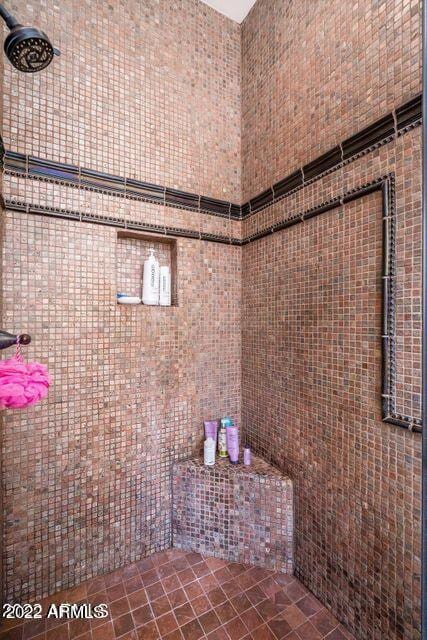 bathroom with tiled shower and tile walls