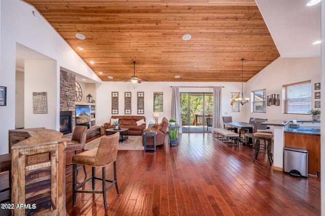 interior space with wooden ceiling, dark hardwood / wood-style floors, a fireplace, and ceiling fan with notable chandelier