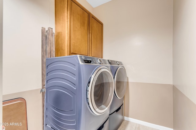 washroom featuring cabinets and washing machine and clothes dryer