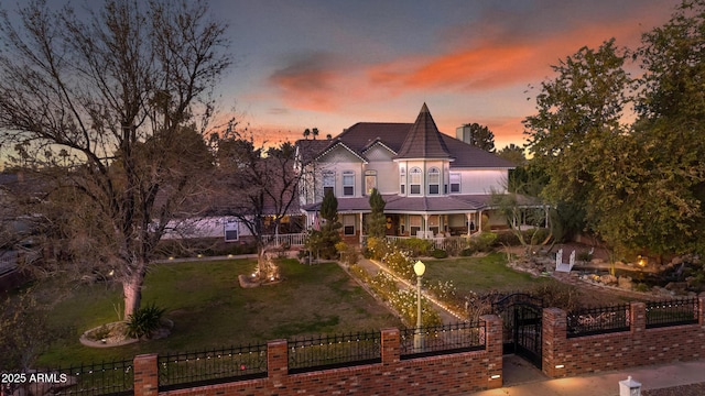 back house at dusk with a lawn