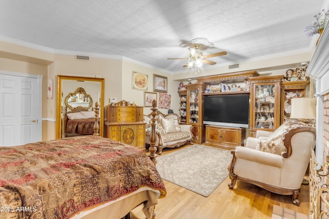 bedroom featuring ornamental molding, wood-type flooring, and a textured ceiling