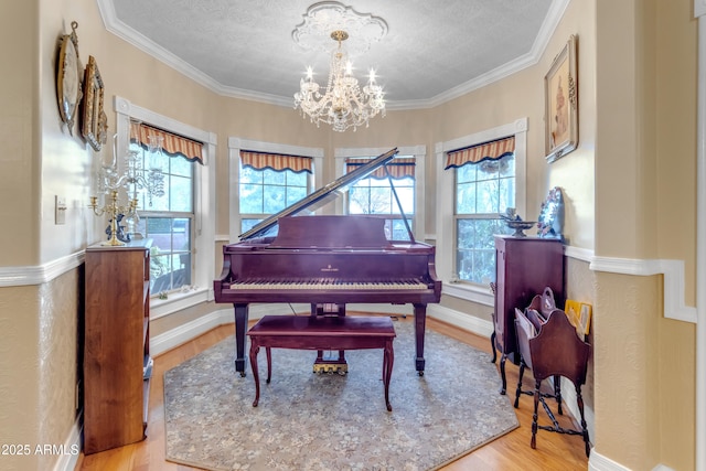 miscellaneous room with crown molding, a chandelier, a wealth of natural light, and light hardwood / wood-style floors