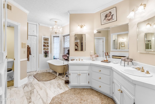 bathroom featuring a notable chandelier, crown molding, a washtub, and vanity