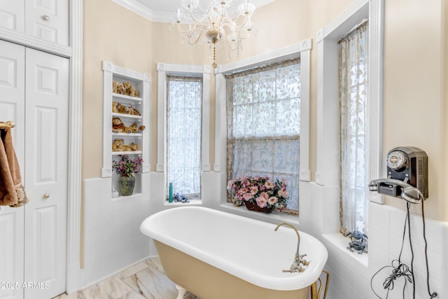 bathroom featuring tile walls, a bath, ornamental molding, and an inviting chandelier