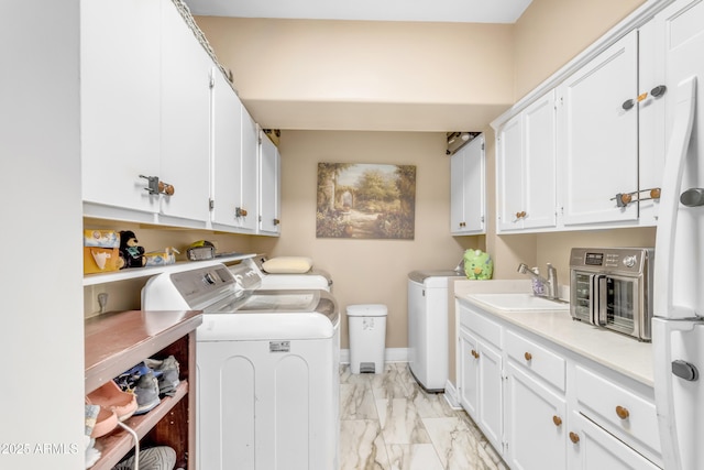 washroom with cabinets, sink, and washing machine and dryer