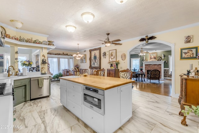 kitchen with dishwasher, a brick fireplace, sink, and plenty of natural light