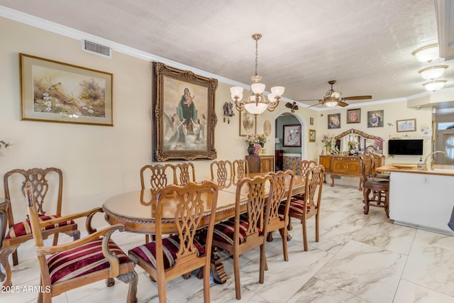 dining space featuring ceiling fan with notable chandelier, ornamental molding, sink, and a textured ceiling