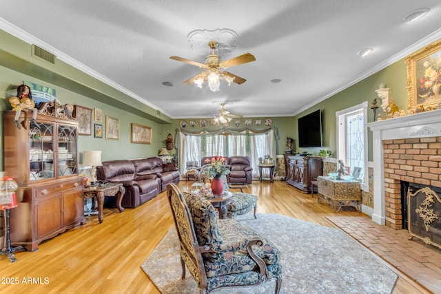 living room featuring hardwood / wood-style floors, crown molding, and a brick fireplace