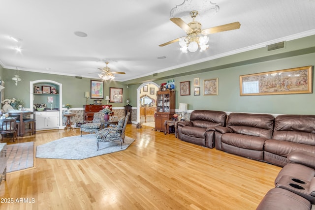 living room with crown molding, ceiling fan, and light hardwood / wood-style floors