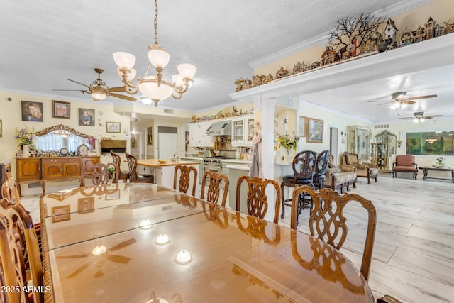 dining room with crown molding and ceiling fan with notable chandelier