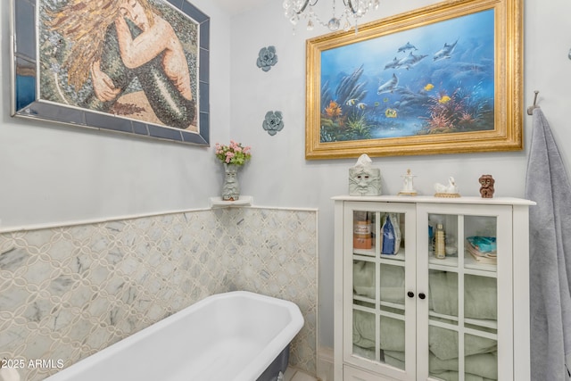 bathroom featuring a washtub and a chandelier