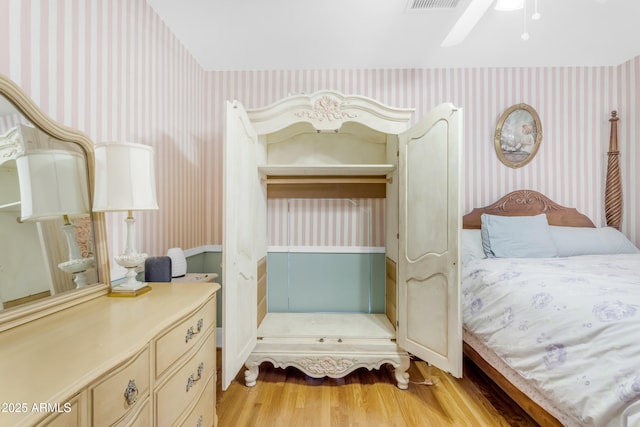 bedroom with light hardwood / wood-style floors and ceiling fan