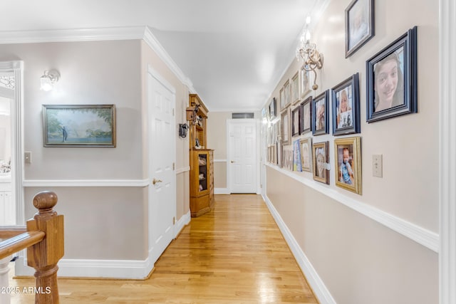 hallway featuring ornamental molding and light hardwood / wood-style floors