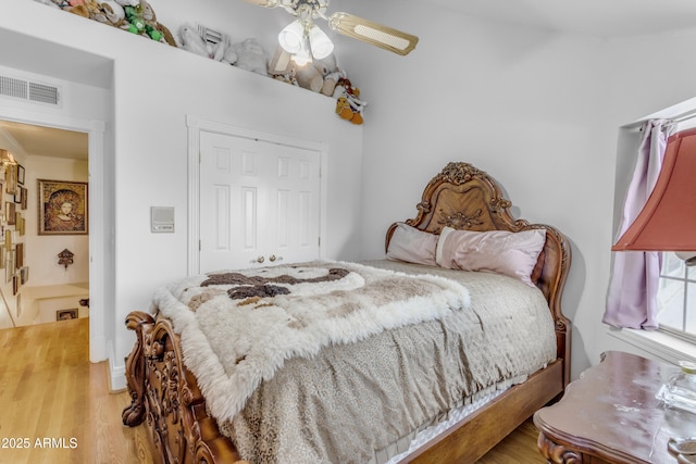 bedroom with wood-type flooring, ornamental molding, and ceiling fan