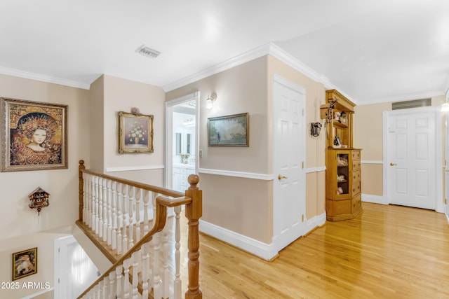 corridor with ornamental molding and hardwood / wood-style floors