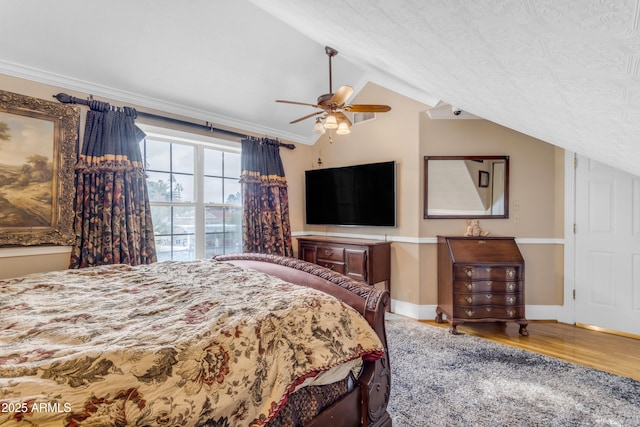 bedroom with crown molding, ceiling fan, lofted ceiling, and wood-type flooring