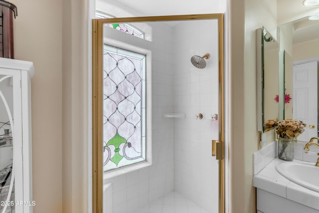 bathroom featuring tiled shower and vanity