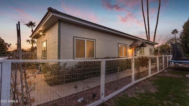 property exterior at dusk featuring a trampoline