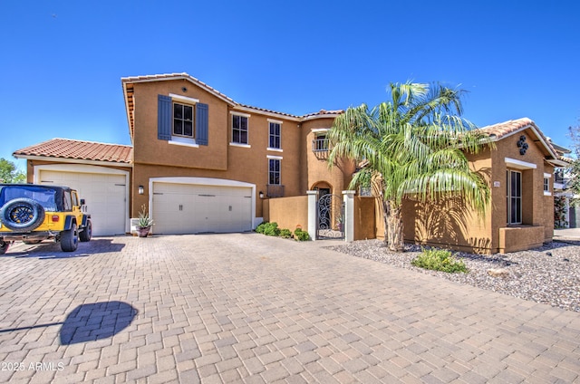 view of front of property with a tile roof, a gate, decorative driveway, and stucco siding