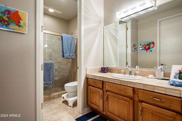 bathroom with vanity, a shower with shower door, toilet, and tile patterned flooring