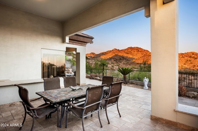 patio terrace at dusk featuring a mountain view