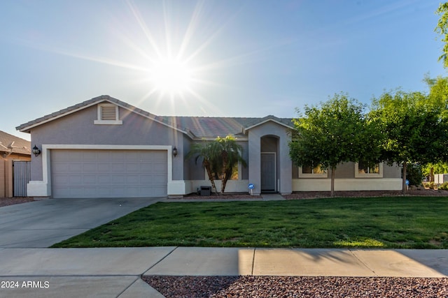 ranch-style house featuring a garage and a front yard