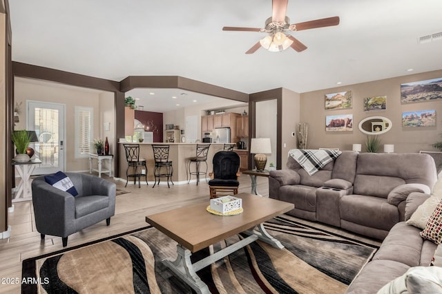 living room with ceiling fan and light wood-type flooring