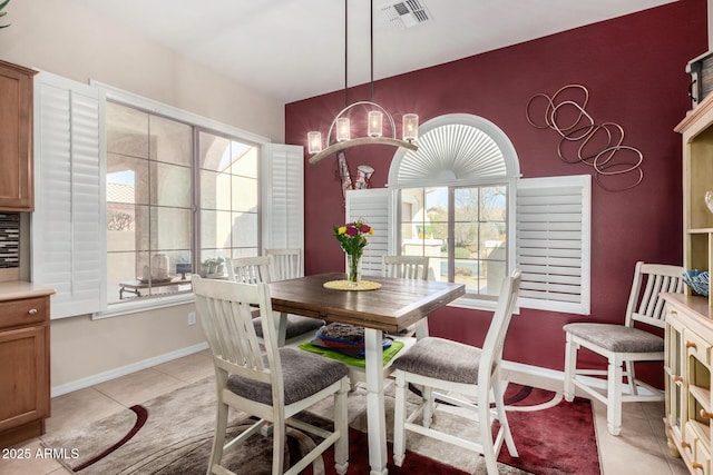 dining room with light tile patterned flooring and a chandelier