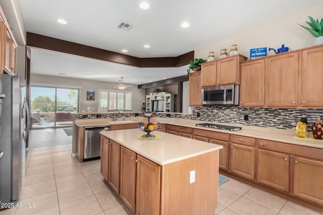 kitchen featuring sink, backsplash, a center island, kitchen peninsula, and stainless steel appliances