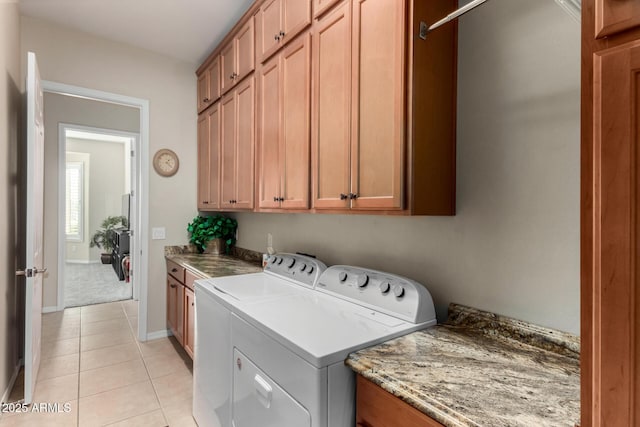 washroom with cabinets, washer and dryer, and light tile patterned floors