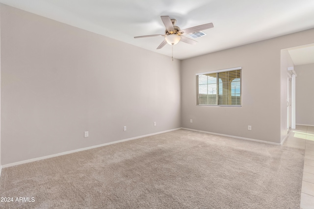 unfurnished room with light colored carpet and ceiling fan