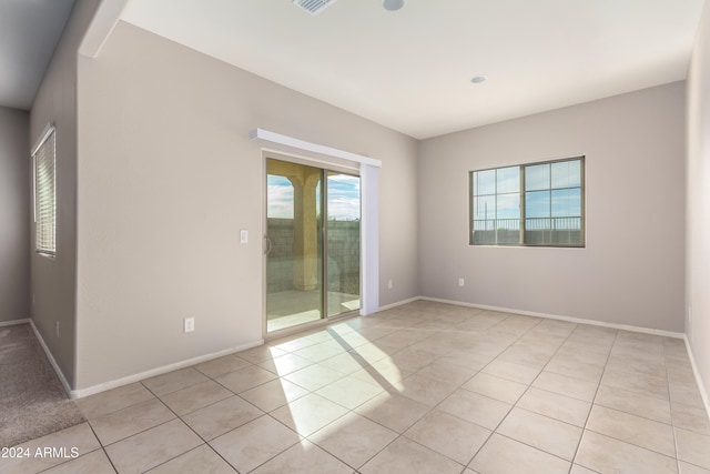 spare room featuring plenty of natural light and light tile patterned floors