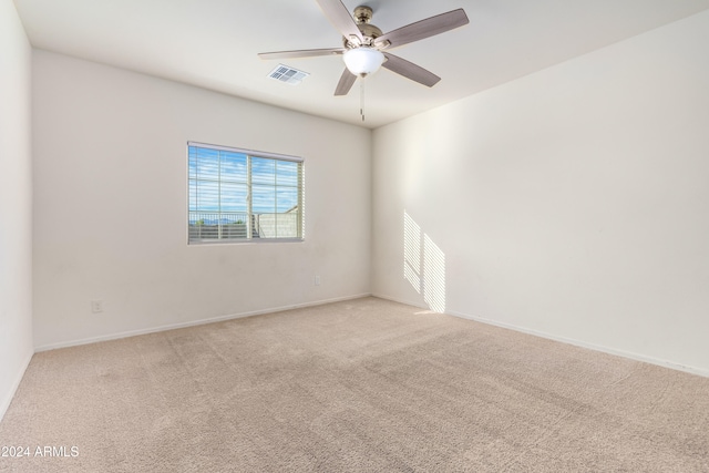 empty room with ceiling fan and light carpet