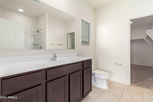 bathroom with a shower, tile patterned floors, toilet, and vanity