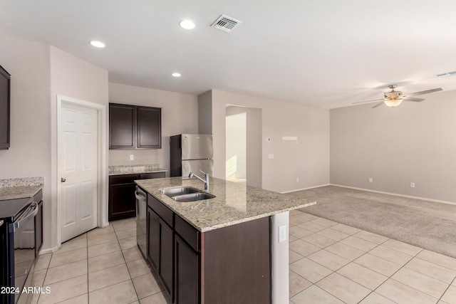 kitchen with dark brown cabinets, appliances with stainless steel finishes, light carpet, and sink