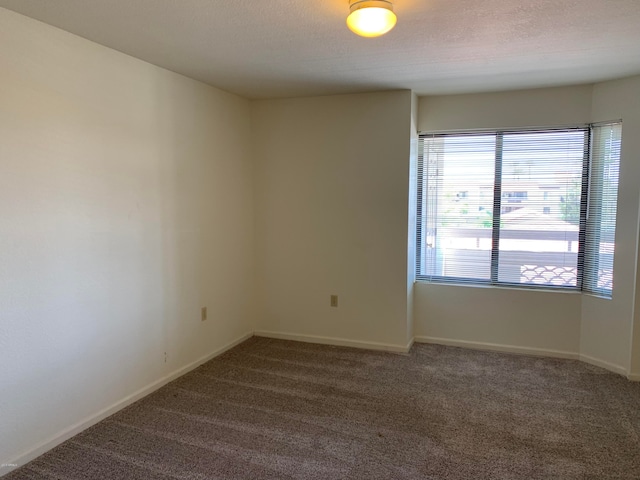 carpeted spare room with a textured ceiling