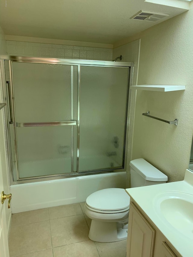 full bathroom with vanity, toilet, tile patterned floors, and bath / shower combo with glass door