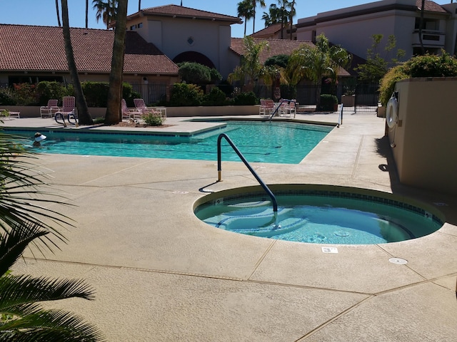 view of pool with a hot tub and a patio area