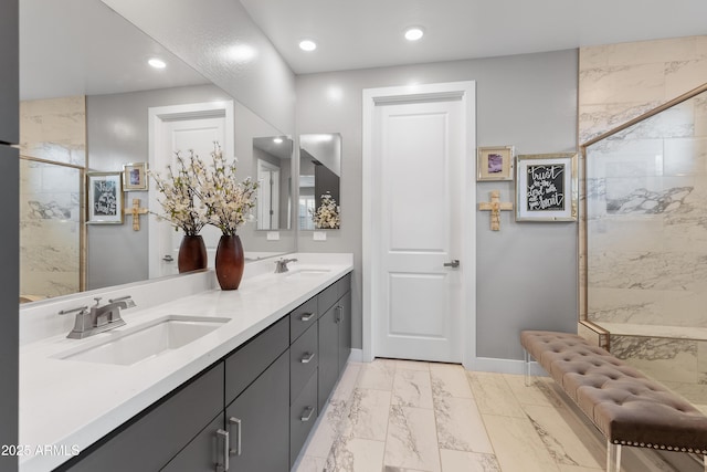 bathroom featuring marble finish floor, baseboards, a sink, and a marble finish shower