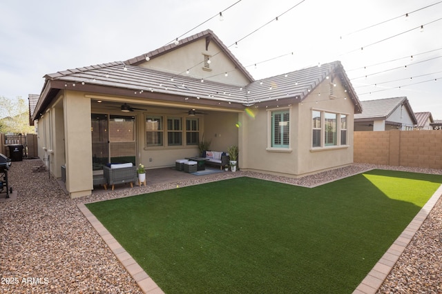 rear view of house featuring a fenced backyard, an outdoor hangout area, a tile roof, stucco siding, and a patio area