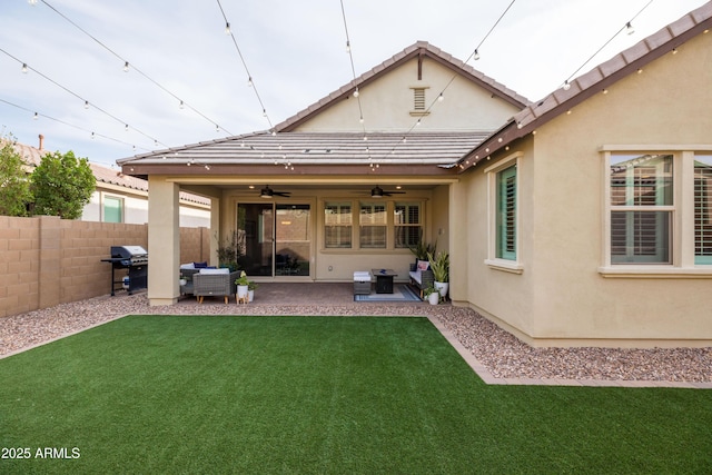 back of property with fence, a lawn, and stucco siding