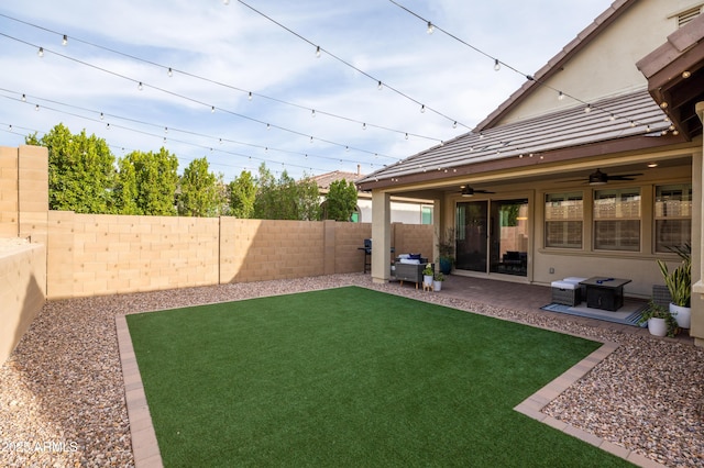 view of yard featuring ceiling fan, a patio area, and a fenced backyard